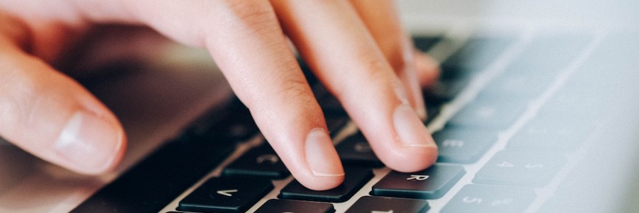 Image of hand on laptop keyboard